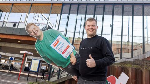 Medewerker met zijn eigen levensgrote bord in zijn handen
